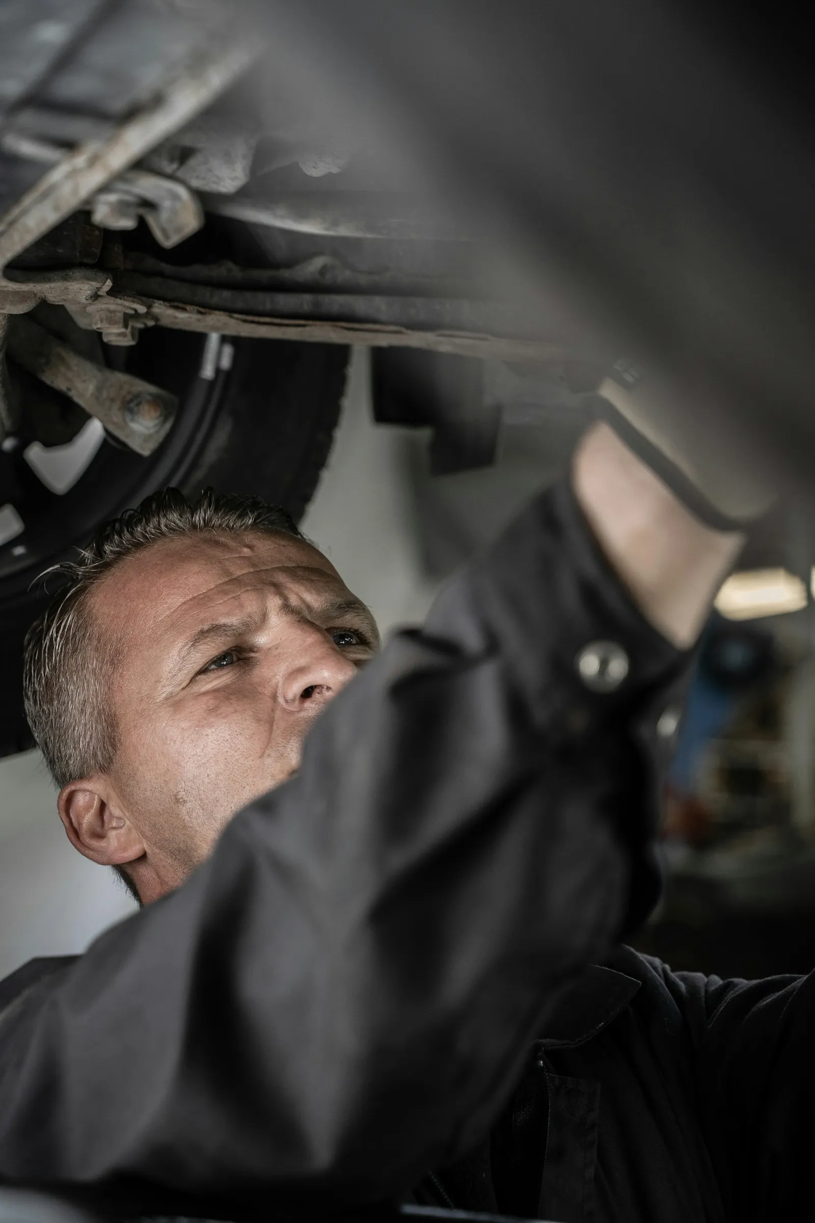 A mechanic inspecting a vehicle for a safety check